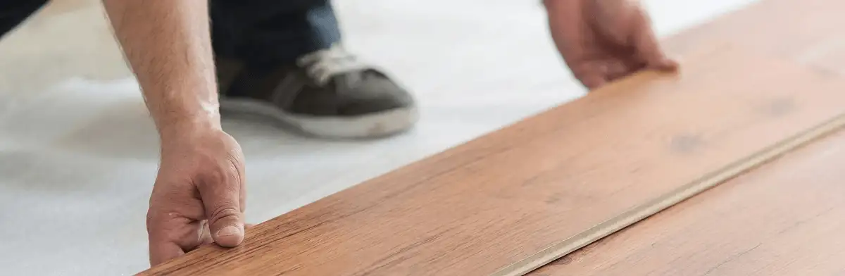 A professional installing laminate flooring in Boston, MA